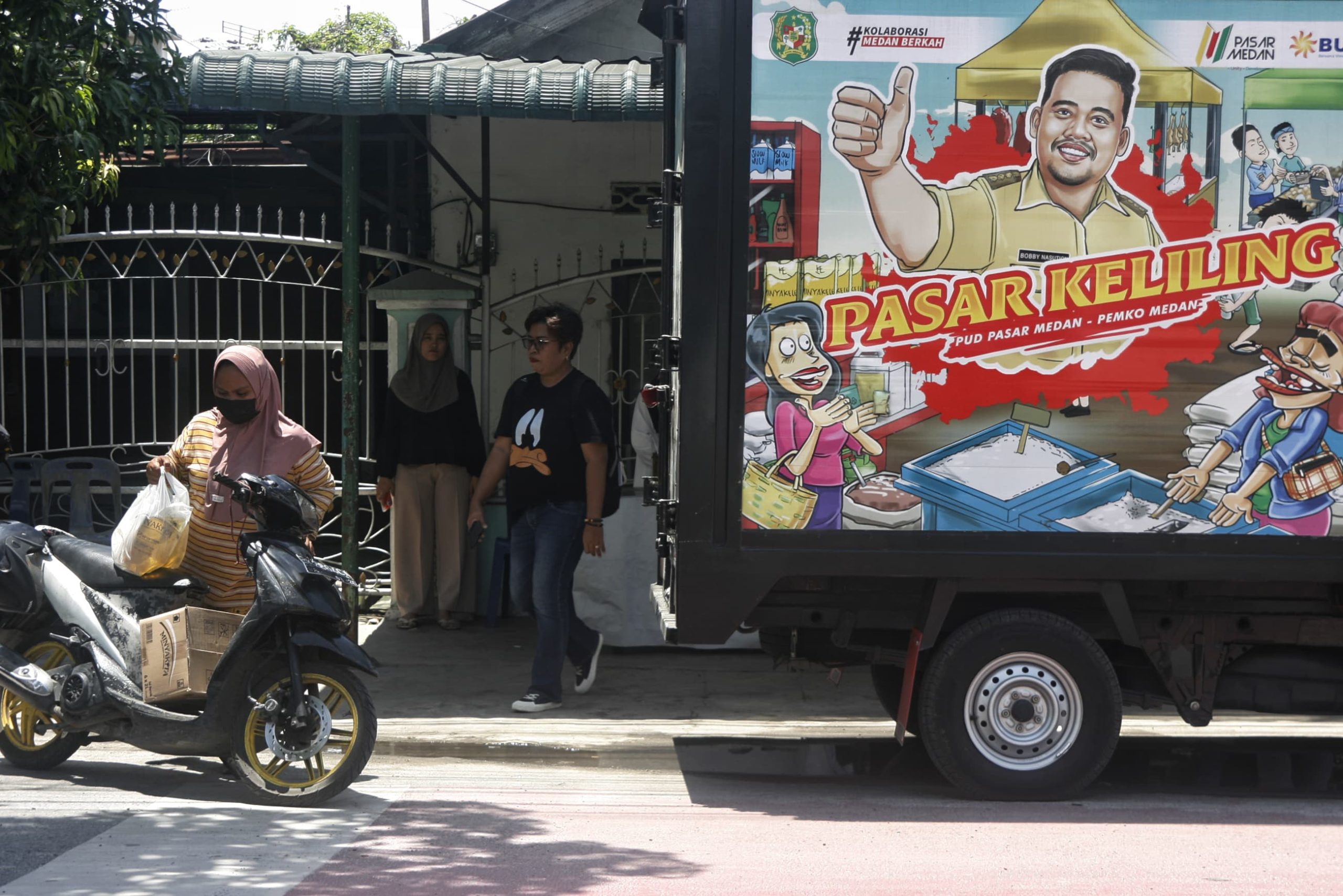 Sejumlah warga setelah usai berbelanja di posko pasar keliling Jalan Bhayangkara, Kelurahan Indra Kasih, Medan Tembung, Medan