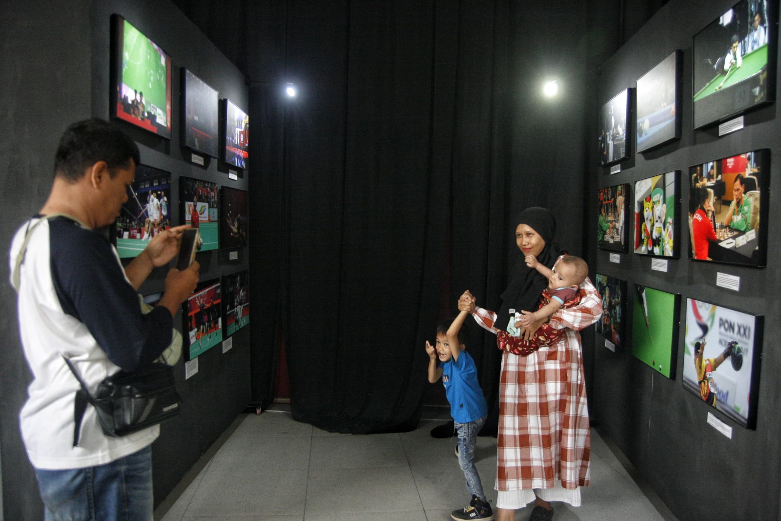 Seorang ibu bersama anaknya berfoto di depan foto yang dipamerkan di Deli Park Mall Medan, Sumatera Utara