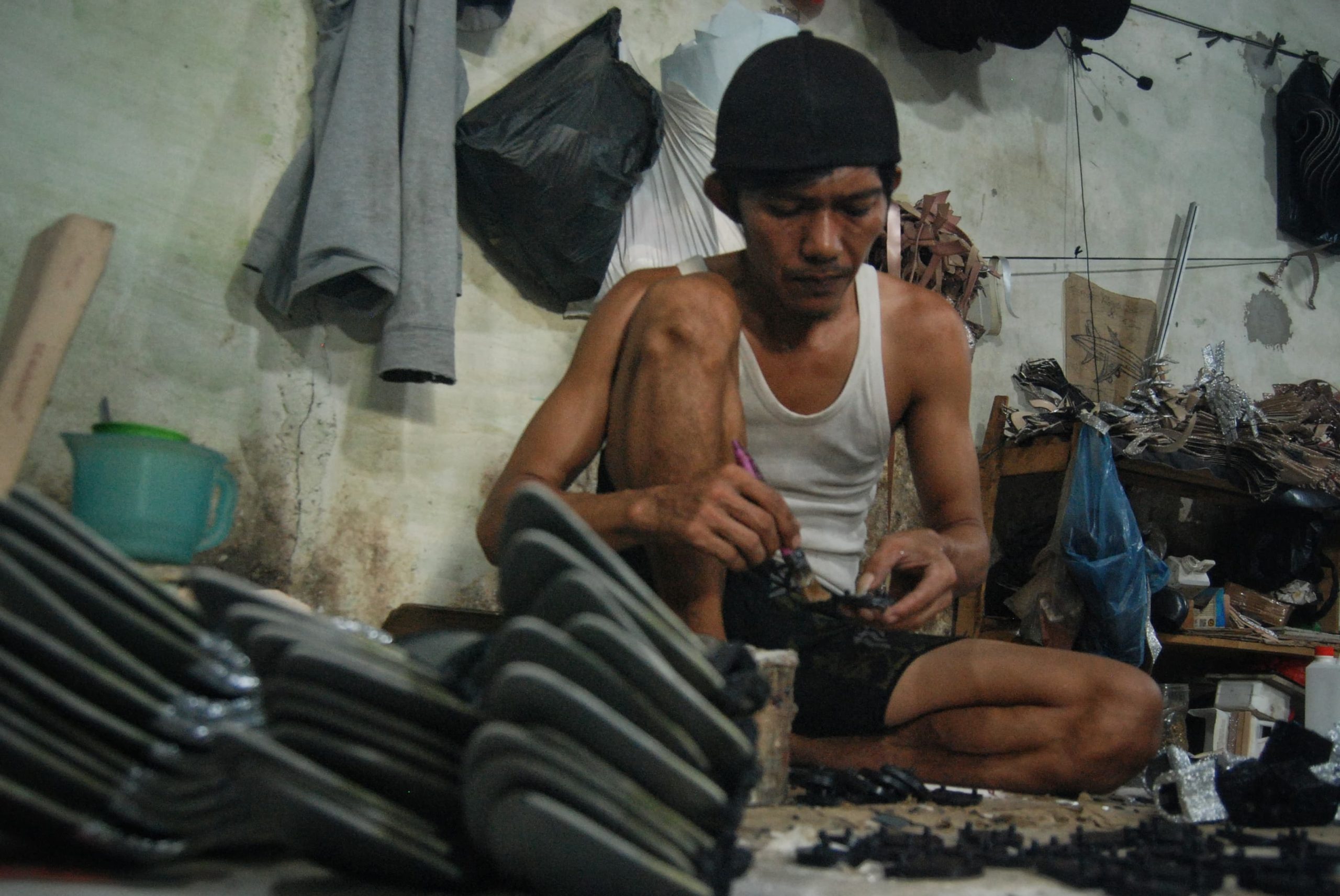 Seorang pekerja melapisi sol sepatu dengan lem di home industri wan piece Jalan Denai, Lorong Sedar, Medan, Sumatera Utara