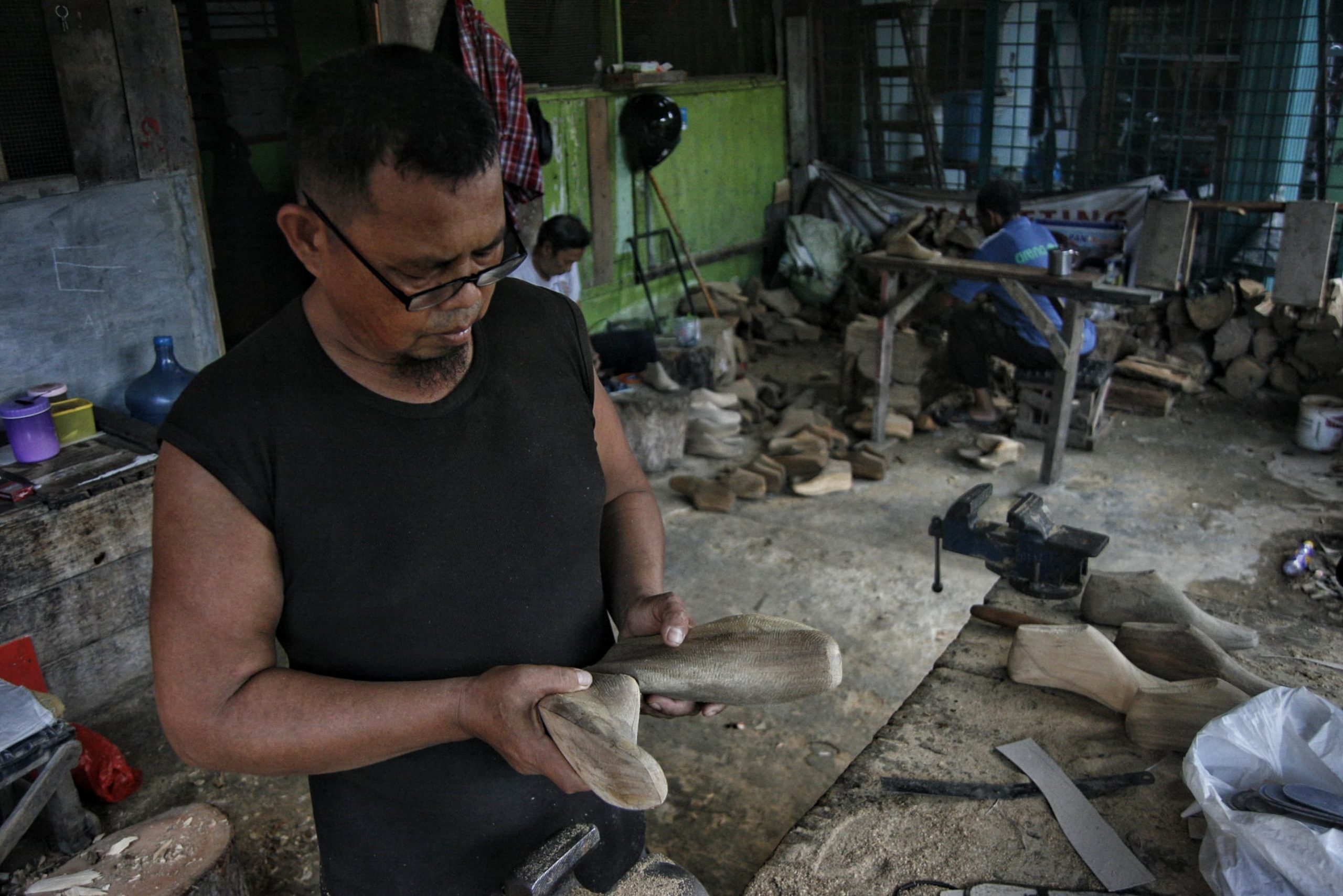 Seorang perajin cetakan sepatu melakukan pengukuran secara manual di Medan Denai, Medan, Sumatera Utara