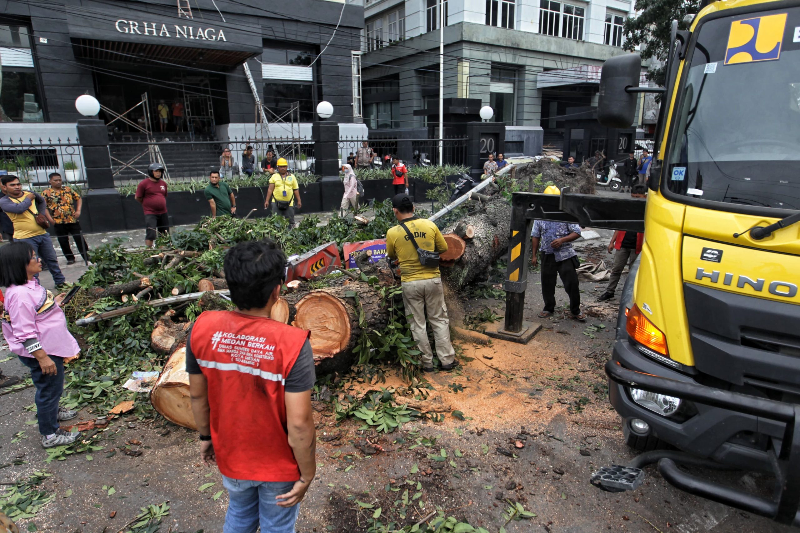 Seorang petugas memotong pohon yang tumbang menggunakan chainsaw di Jalan Putri Hijau, Kota Medan