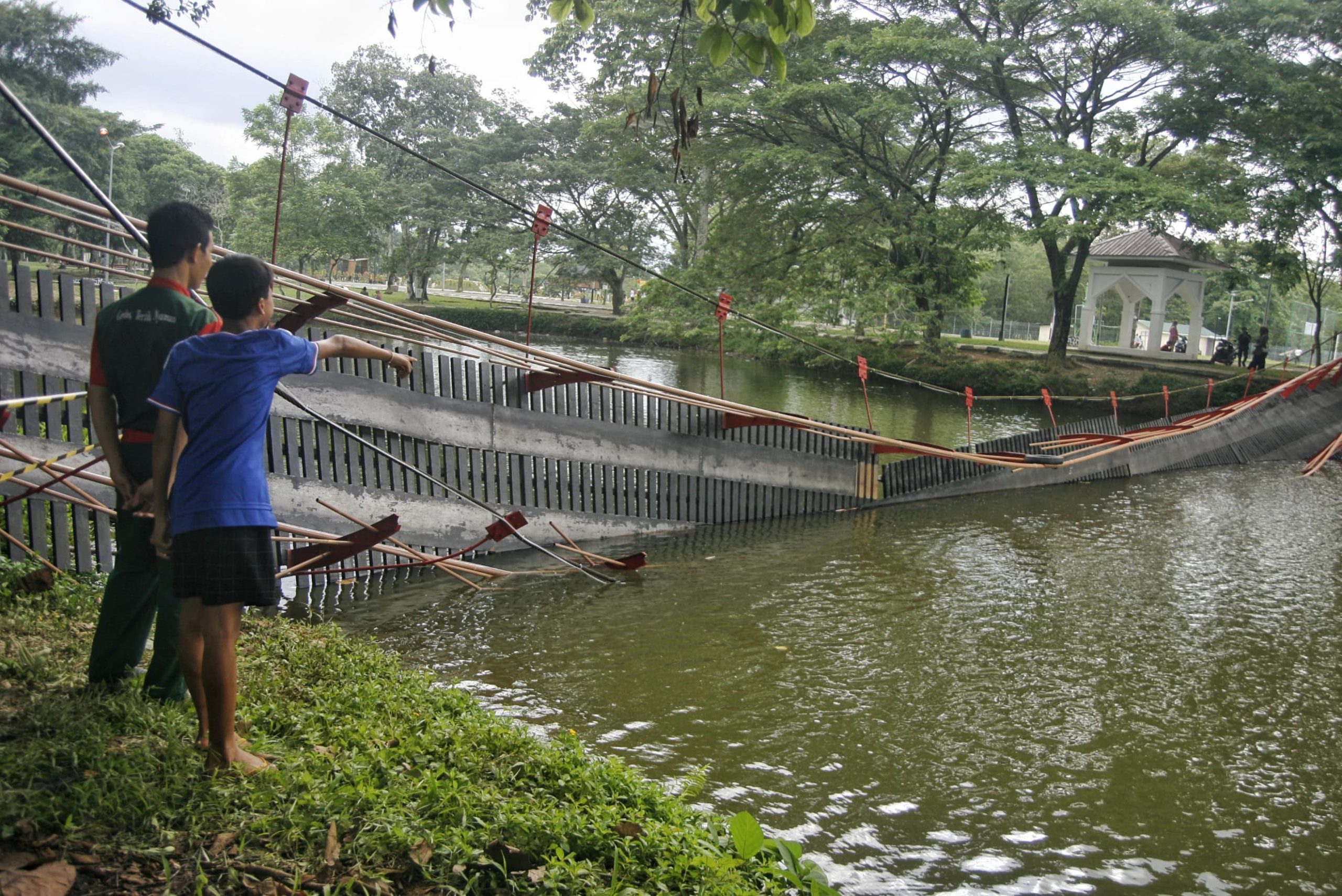 Warga menunjuk ke arah jembatan yang ambruk di Taman Cadika, Medan, Sumatera Utara