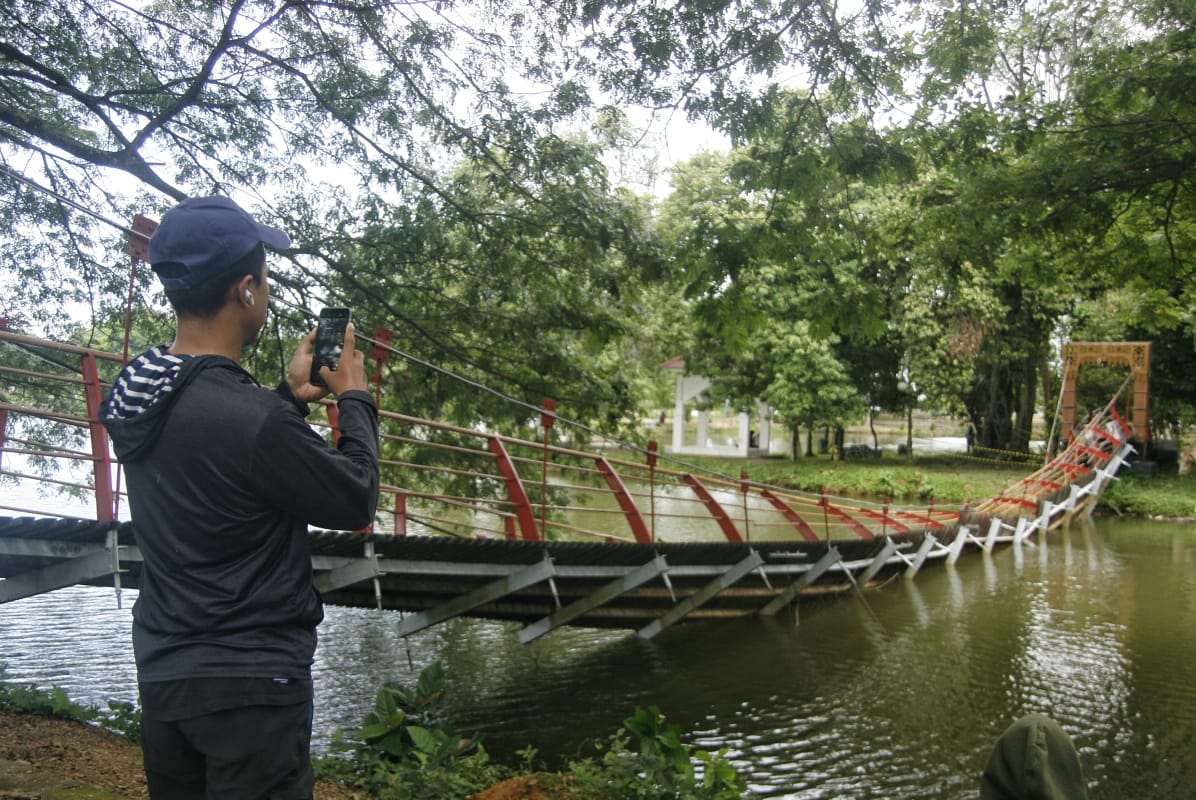 Warga merekam jembatan yang ambruk di Taman Cadika, Medan, Sumatera Utara menggunakan handphone