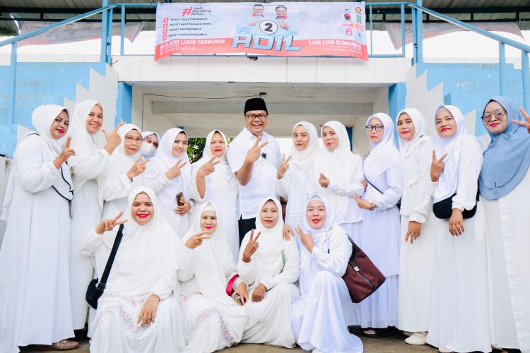 Calon Bupati Deli Serdang H. Asri Ludin Tambuan foto bersama dengan ibu-ibu perwiridan memberikan kata sambutan di Lapangan Sepak Bola Desa Sei Semayang Kecamatan Sunggal, Jumat (18/10/24). 