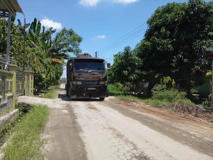 Dump truk yang mengangkut tanah dari bantaran Sungai Ular sehingga mengakibatkan kerusakan aspal yang dilaluinya.