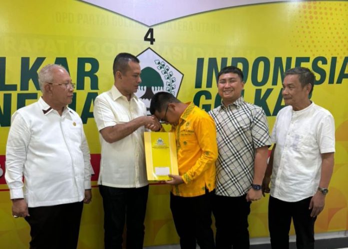 Rimba Bertuah Sitorus (baju kuning) didampingi Ketua DPD Partai Golkar Labura Hendriyanto Sitorus menerima SK penunjukan dirinya sebagai Ketua DPRD Labura dalam sebuah acara di Medan, Senin (14/10/24).