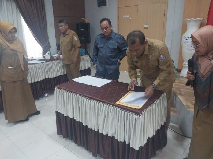 Sekretaris Dinas SDABMBK Deli Serdang, Suparno menandatangani pakta integritas forum konsultasi pelayanan publik di Aula II SDABM BK, Selasa (15/10/24).