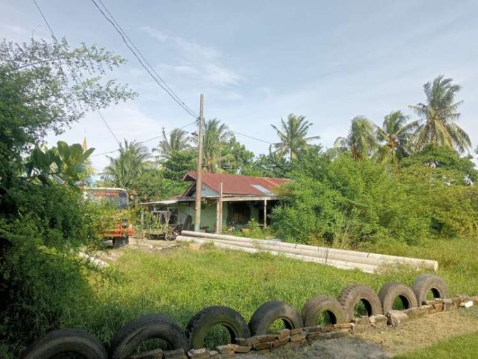 Tiang listrik beton yang sebelumnya tergeletak dan ditutupi rumput berbulan lamanya telah dipindah ke halaman rumah warga.