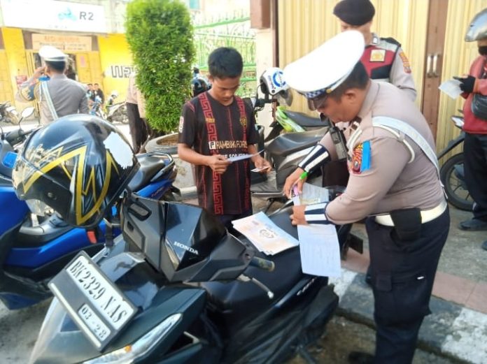 Petugas Satlantas Polres Tebing Tinggi saat memberikan tilang kepada pengendara sepeda motor.