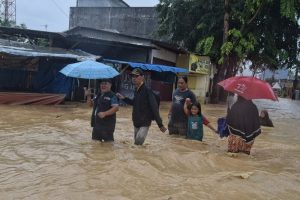 Petugas Bawaslu Medan berjalan melintasi banjir menuju lokasi TPS 012 di Jalan Selamat, Sitirejo III, Medan Amplas, Sumatera Utara, Rabu (27/11/2024) untuk mengawasi pengamanan logistik setelah pencoblosan tidak dilakukan (f:adil/mistar)