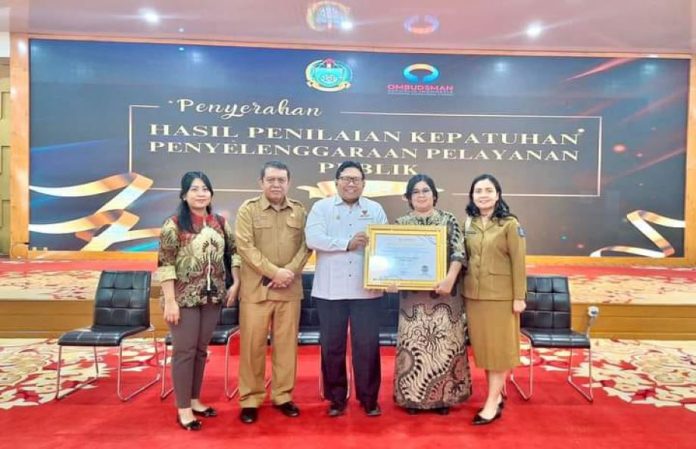 Pimpinan Ombudsman RI Dadan Suparjo Suharmawijaya menyerahkan penghargaan kepada Plt. Sekda Kota Sibolga Juneidi Tanjung didampingi Kepala Bagian Organisasi Susana Oktariana Megaria Sibuea