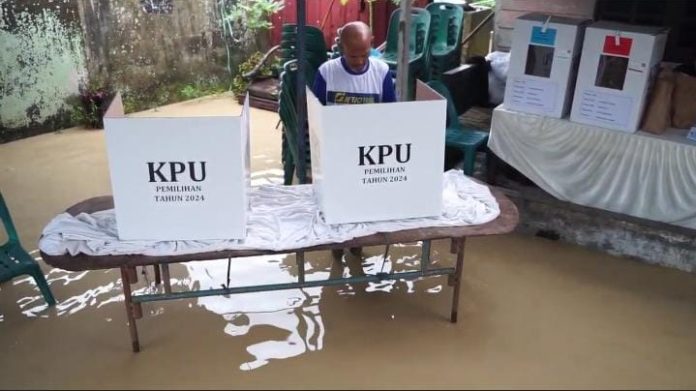 Warga Desa Tanjung Gusta Kecamatan Sunggal Kabupaten Deli Serdang menggunakan hak pilihnya di TPS 01 saat banjir melanda. (f:diyus/mistar)