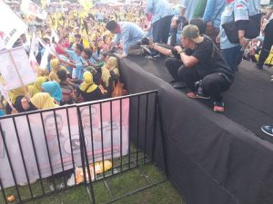 Asri Ludin Tambunan dan Lom Lom Suwondo menyapa massa sambil berjongkok pada kampanye akbar di Lapangan Reformasi Desa Bandar Klippa,Selasa (19/11/24). f:rinaldi/mistar)