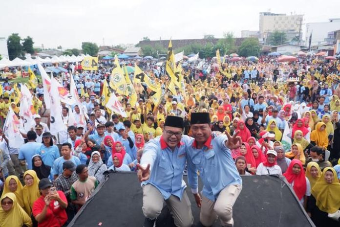 Asri Ludin Tambunan dan Lom Lom Suwondo foto bersama di hadapan ribuan massa pada kampanye akbar di Lapangan Reformasi Desa Bandar Klippa,Selasa (19/11/24). (f:rinaldi/mistar)