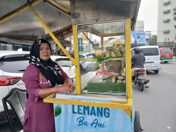 Andriani, salah seorang pedagang lemang di pinggiran Jalan Gatot Subroto, Medan Petisah. (f: devi/mistar)