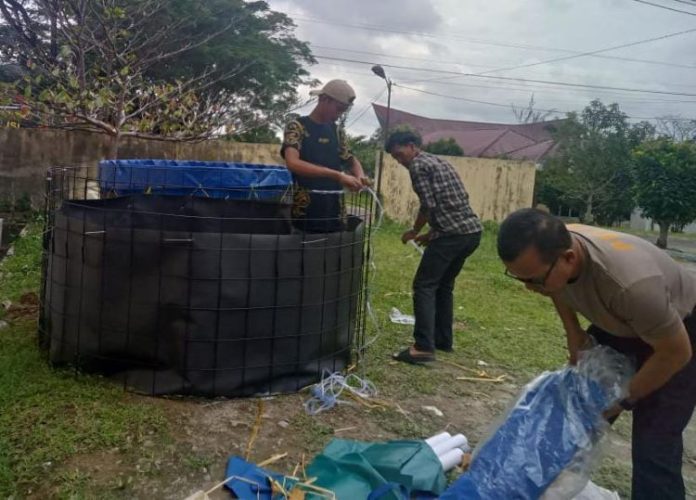 Personil Kepolisian saat membuat kolam ikan dalam program mendukung ketahan pangan.