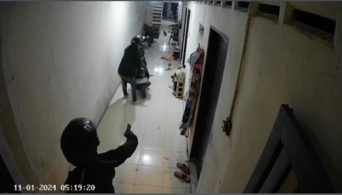 Kedua pelaku terekam CCTV, salah satu terlihat memegang benda seperti senjata api.