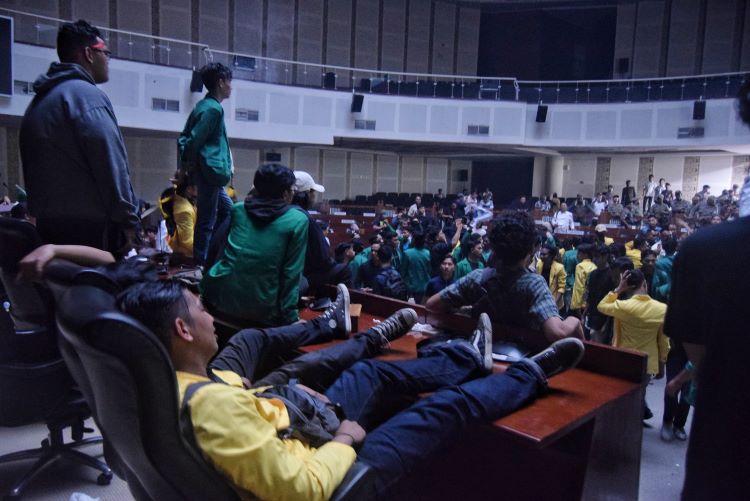 Mahasiswa tengah duduk di kursi anggota dewan saat berunjuk rasa di dalam Gedung Ruang Rapat Paripurna DPRD Sumut, Medan, Senin (30/12/24).