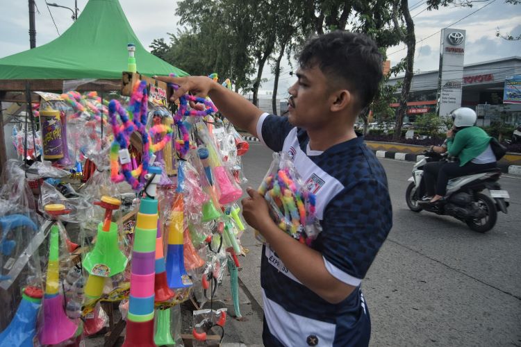 Penjual terompet merapikan dagangannya di Jalan Sisingamangaraja, Medan, Selasa (31/12/24). 