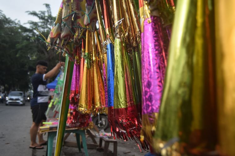 Penjual terompet merapikan dagangannya di Jalan Sisingamangaraja, Medan, Selasa (31/12/24). 