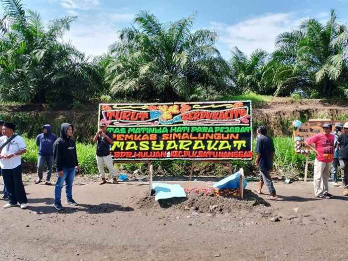 Warga Kecamatan Bandar Huluan dan Kecamatan Dolok Batu Nanggar, Kabupaten Simalungun, bangun 'kuburan' di tepi jalan sebagai bentuk protes jalan rusak (f:ist/mistar)