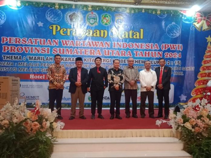 Pj Gubernur Sumut Agus Fathoni (baris ke empat) saat menghadiri Natal yang dilaksanakan oleh Keluarga Besar Persatuan Wartawan Indonesia (PWI) Sumut di Hotel Danau Toba Internasional (HDTI), Jalan Imam Bonjol Medan, Rabu (18/12/2024) malam. (f:saut/mistar)