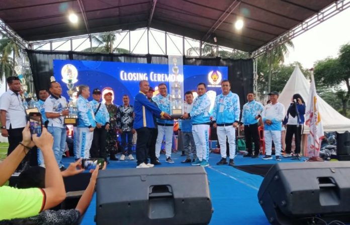 Pj.Sekda Deli Serdang, Citra Effendi Capah bersama Ketum KONI, dr. Aci menyerahkan tropi juara umum I kepada Camat Biru-Biru Rahmat Hidayat