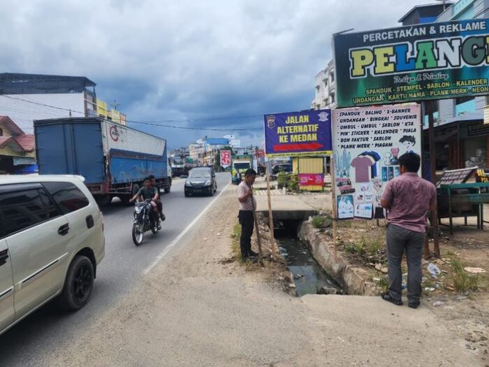 Personel Polres Labusel memasang rambu Jalur Alternatif mudik Nataru. (f: ist/mistar)