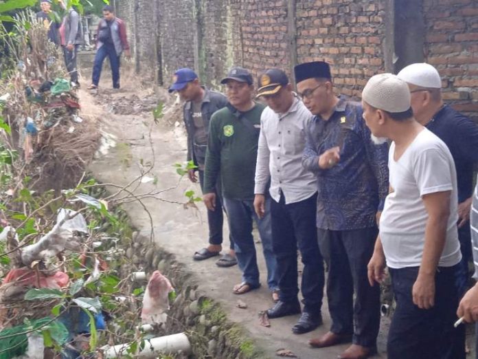 Datuk Iskandar Muda (kemeja batik biru), anggota Komisi IV DPRD Kota Medan saat meninjau lokasi terdampak banjir di Kampung Lalang.