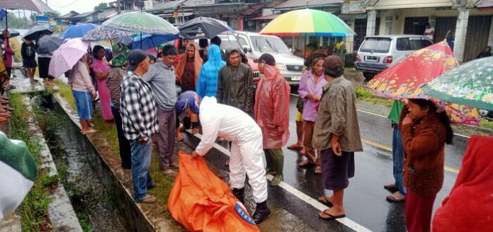 Warga Desa Lae Hole, Kecamatan Parbuluan, Kabupaten Dairi, menyaksikan petugas mengevakuasi korban dari parit (f:ist/mistar)