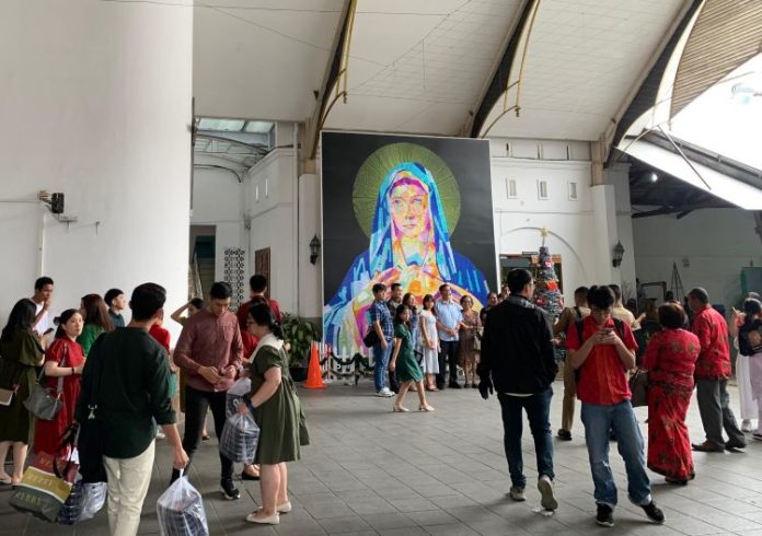 Gereja Katolik Kristus Raja yang memajang lukisan Bunda Maria sebagai icon foto bersama keluarga para jemaat yang beribadah pada hari Natal 2024 (25/12/24).