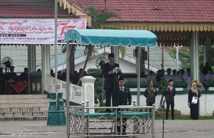 Asisten Administrasi Pemerintahan dan Kesejahteraan Rakyat (Aspem dan Kesra) Kota Tebing Tinggi Bambang Sudaropno saat membacakan amanat Peresiden RI di Hari Bela Negara Ke-76.