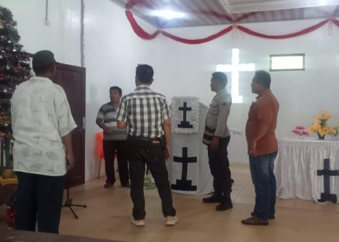 Petugas kepolisian bersama warga saat berada di gereja HKBP Dolok Jetun