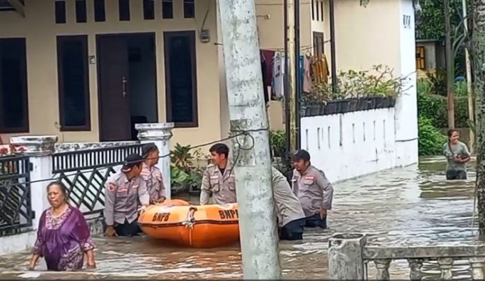 Petugas BPBD Binjai mengevakuasi warga terdampak banjir di kelurahan Rambung Barat.