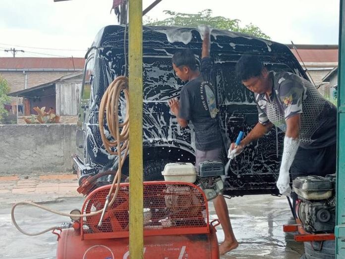 Tempat cucian mobil tradisional masih diminati banyak pemilik mobil dan sepeda motor.(f:sembiring/mistar)