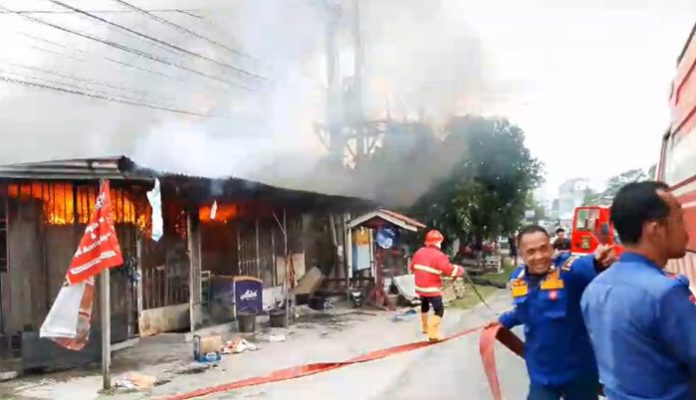 Petugas pemadam kebakaran saat berusaha mematikan kobaran api di grosir yang ada di Kisaran. (f:ist/mistar)